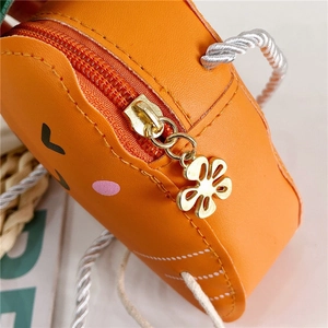 Détail macro du sac enfant orange avec fermeture éclair fleur et bandoulière en corde