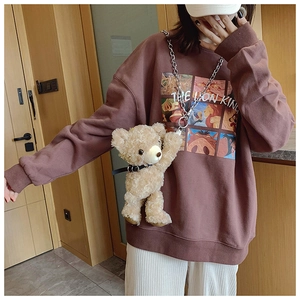 Detail of cute brown plush bear crossbody bag with silver chain strap on model