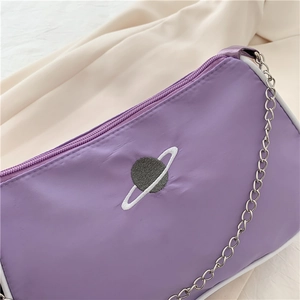 Close-up of purple nylon baguette bag with planet embroidery and silver chain strap
