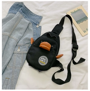 Detail of cute black duck canvas chest bag with orange beak and adjustable strap