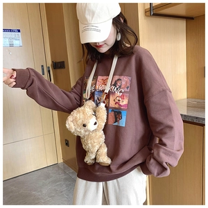 Detail showing the fluffy light brown teddy bear plush crossbody bag with casual outfit