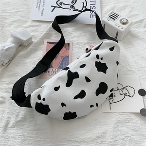 Stylish canvas cow print crossbody bag with adjustable black strap on white background