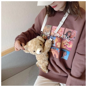 Close-up of a plush bear crossbody bag styled with a Lion King graphic sweatshirt
