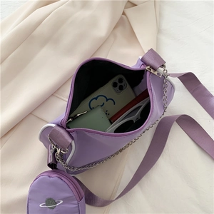Top view of purple nylon crossbody bag with inner lining, round pouch, and chain strap