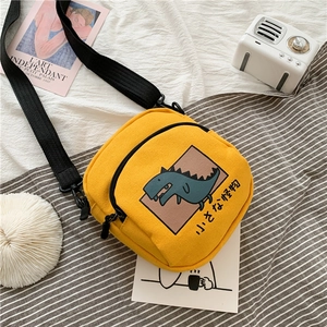 Détail du petit sac bandoulière en toile jaune avec dinosaure et sangle ajustable