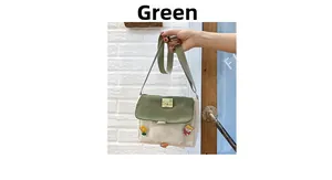Détail du sac bandoulière en toile vert et beige avec pendentifs de dessin animé