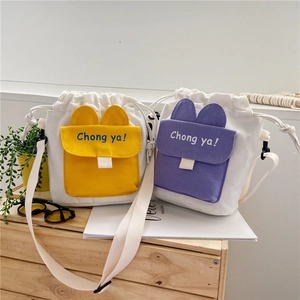 Detailed shot of yellow and purple canvas bucket bags with cute ears and adjustable straps