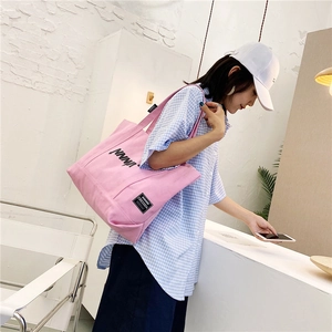 Pink canvas tote bag detail showing shoulder strap fit and large storage capacity