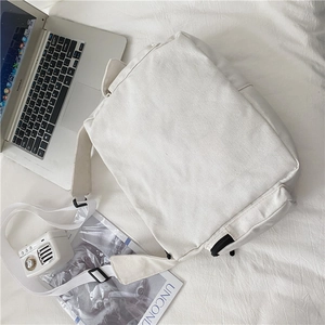 Macro shot of durable off-white canvas bag with black metal zipper and adjustable strap