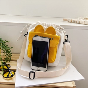 Canvas drawstring crossbody bag detail with yellow pocket and bunny ear design