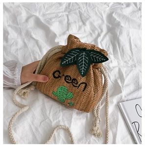 Detail of straw bucket bag featuring green cactus embroidery and cotton rope strap