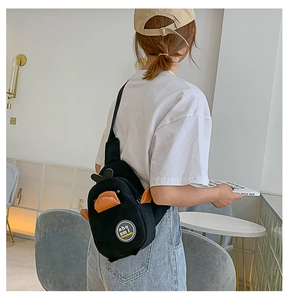 Detailed view of the black canvas crossbody bag with cute orange duck ornament design