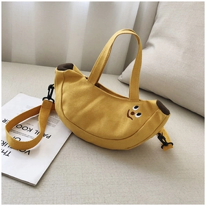 Détail du sac en toile jaune en forme de banane avec broderie sourire et large bandoulière
