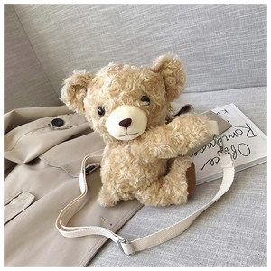 Detail of teddy bear plush bag with curly faux fur and adjustable beige strap on a trench coat