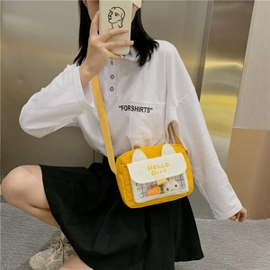 Detail of yellow canvas crossbody bag featuring cute rabbit ears and clear PVC window