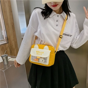 Detail of yellow cartoon crossbody bag featuring rabbit ears and a clear plush toy window