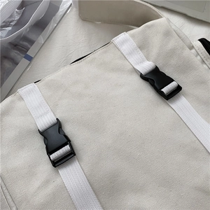 Detailed macro view showing durable white canvas texture and black plastic buckles on strap