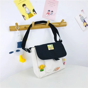 Détail du sac bandoulière en toile avec badges mignons et large sangle réglable
