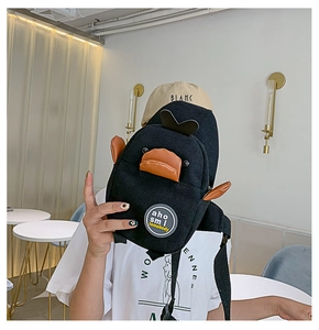 Detail of cute black canvas duck crossbody bag with adjustable strap in a cafe setting