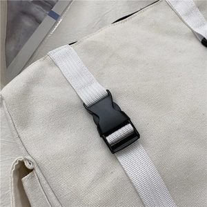 Detailed close-up of durable white canvas fabric with black quick-release buckle and webbing