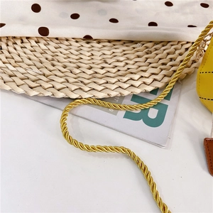 Détail d'un sac jaune matelassé avec bandoulière en corde tressée dorée épaisse