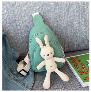 Détail du sac bandoulière en toile vert menthe avec pendentif lapin et large sangle