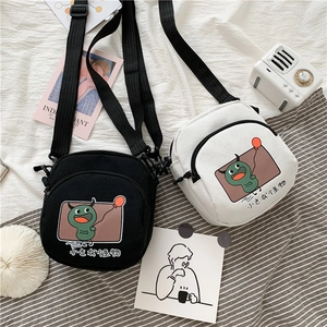 Détail de sacs bandoulière en toile avec imprimé petit monstre et sangle réglable