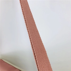 Gros plan détaillé de la bandoulière tissée avec coutures précises sur un sac rose