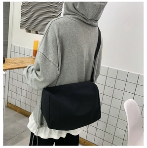 Vista posteriore di una borsa a tracolla nera capiente in tela con spallina larga