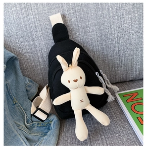 Détail du sac de poitrine en toile avec lapin en peluche et doubles fermetures à pompon