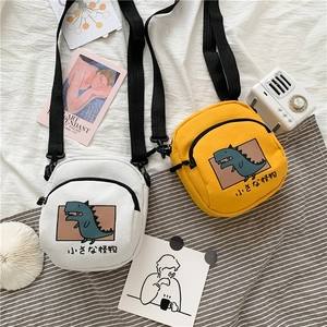 Détail de mini sacs bandoulière en toile avec dinosaures cartoon et sangle réglable