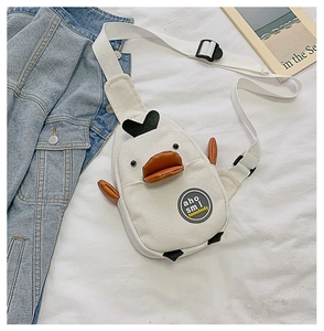 Detailed close-up of white canvas duck bag featuring orange 3D beak and embroidery