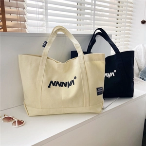 Detail of canvas tote bag showing NNNVA logo and Cressida fabric tag on thick fabric