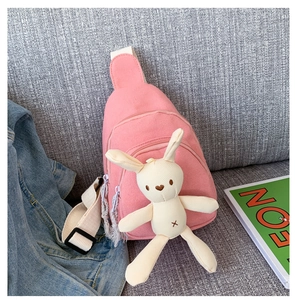 Détail du sac de poitrine en toile rose avec pendentif en peluche lapin blanc mignon
