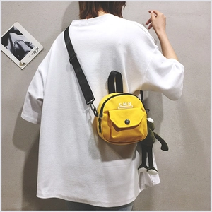Détail du sac bandoulière en toile jaune gingembre avec pendentif grenouille et CMN