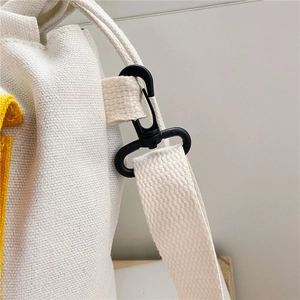 Detailed macro view of sturdy black plastic swivel lobster clasp on a beige canvas bag
