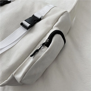 Detailed macro view of white canvas bag showing plastic buckle and black zipper pocket