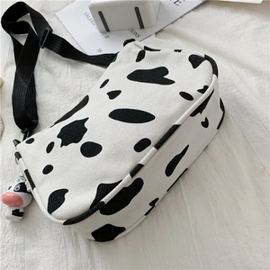 Dettaglio della borsa in tela con stampa mucca, peluche 3D e tracolla regolabile