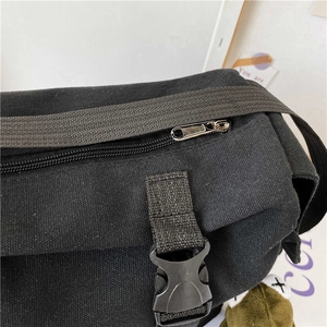 Dettaglio della borsa in tela nera con cerniera in metallo e fibbie in plastica resistenti