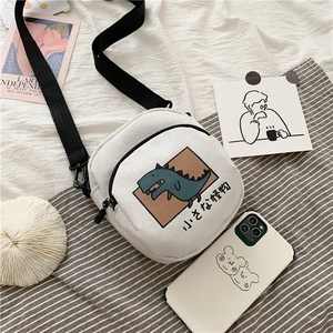 Gros plan du mini sac en toile blanche avec dinosaure bleu et texte japonais