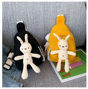 Détail des sacs bandoulière en toile jaune et noir avec un mignon lapin en peluche