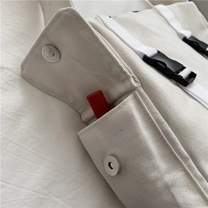 Detail view of canvas bag side pocket with magnetic closure and lipstick storage