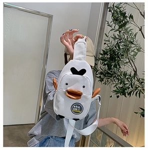 Detail of white canvas crossbody bag featuring cute cartoon duck design with 3D beak wings