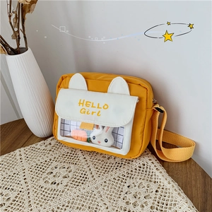 Detail of yellow canvas crossbody bag featuring 3D ears and transparent rabbit pocket