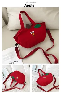 Détail du sac en toile rouge en forme de pomme avec broderie et bandoulière réglable
