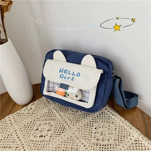 Detail of blue canvas crossbody bag with animal ears and transparent PVC window