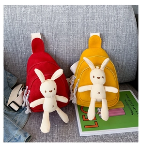 Détail des sacs de poitrine en toile rouge et jaune avec lapin en peluche et large bandoulière