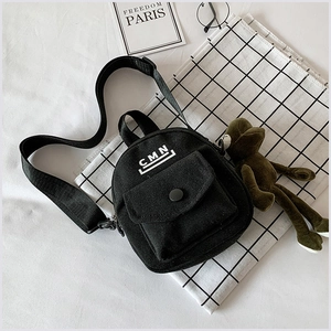 Vue détaillée du sac bandoulière en toile noire avec logo CMN blanc et bandoulière réglable