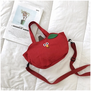 Détail macro du sac en toile rouge en forme de pomme avec broderies et décorations