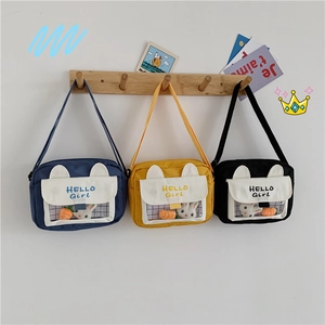Detail of canvas crossbody bags with rabbit plush in yellow, navy, and black colors